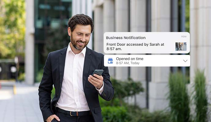 Businessman reviewing smart commercial security notifications and access alerts on a mobile phone