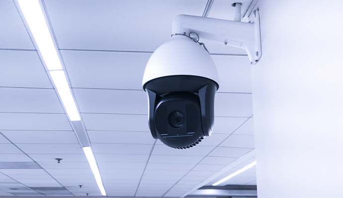 Commercial PTZ dome security camera mounted on an office ceiling