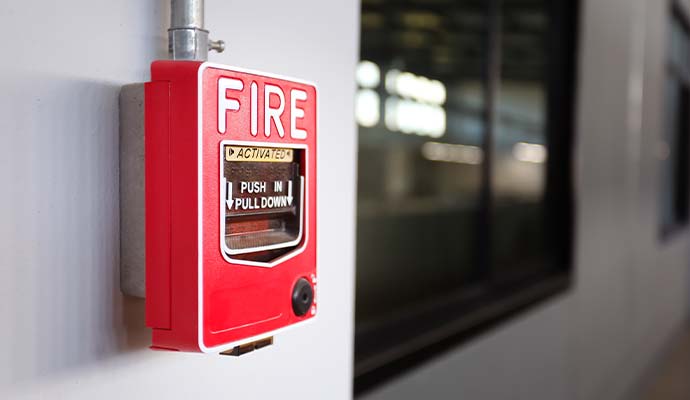 Red wall-mounted commercial fire alarm manual pull station
