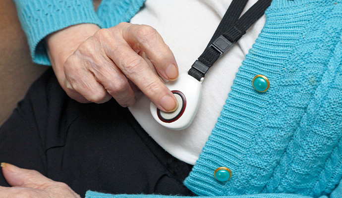 Elderly person interacting with medical alert pendent