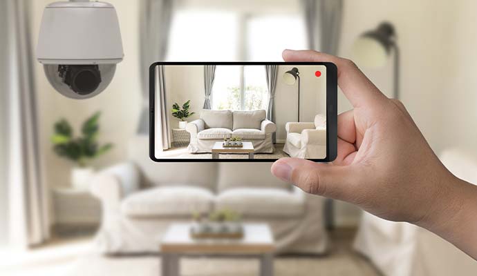 Smartphone displaying live home security camera feeds of a living room