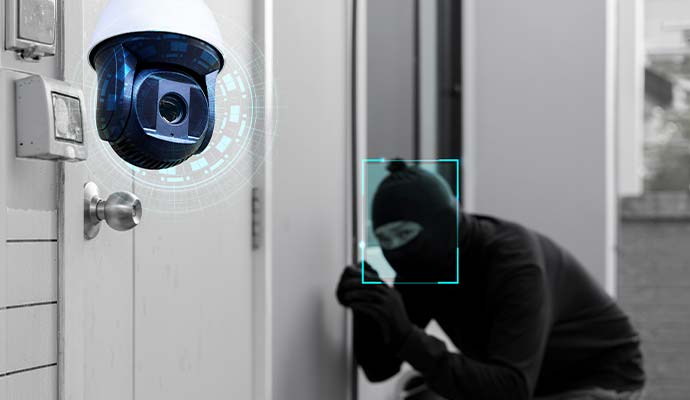 Security camera with facial tracking detecting a masked intruder attempting to enter a building
