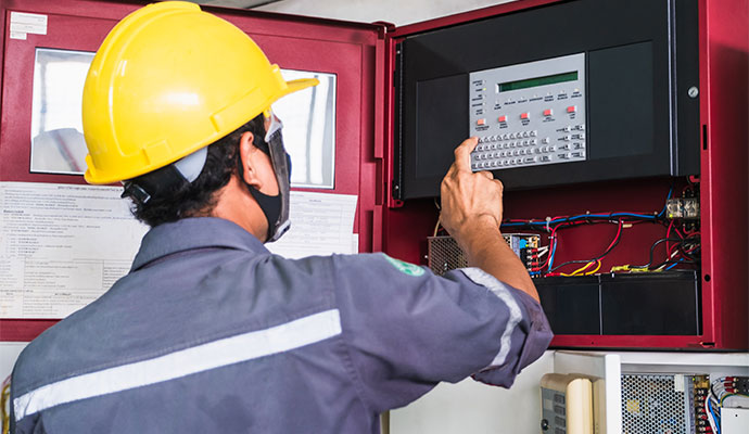 Technician operating open red fire alarm cabinet