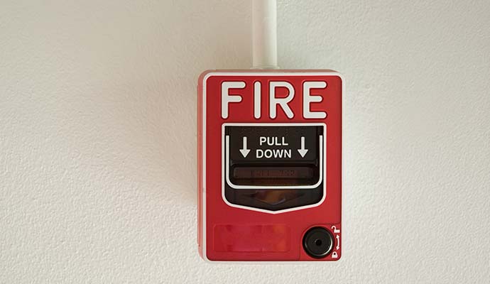 Red wall-mounted emergency fire alarm pull station