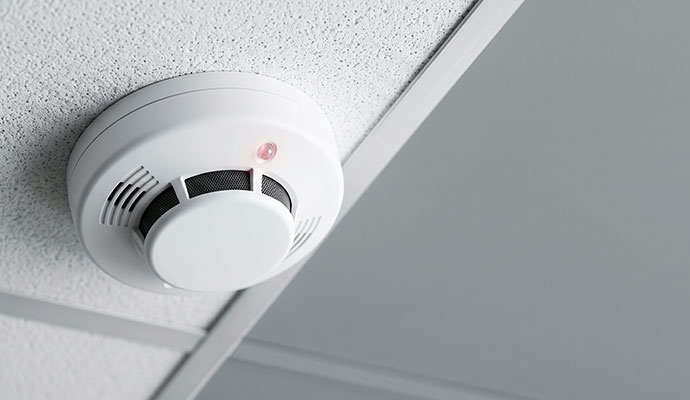 White smoke detector with red led on ceiling