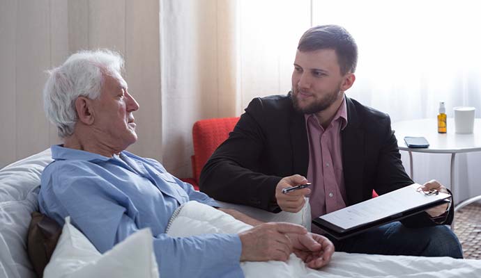 Emergency mobile notary assisting a patient in a hospital bed with medical document signing