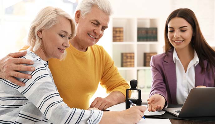 Mobile notary assisting senior couple with document signing