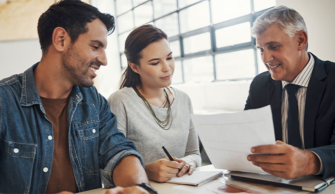 Tax advisor reviewing paperwork with a couple in an office