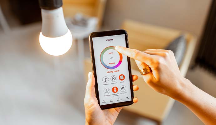 A close-up view of a person using a smartphone app to adjust color of a light