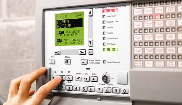 A person operating fire alarm control panel
