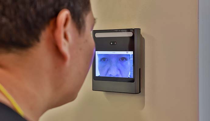 A person using wall mounted retina scanner