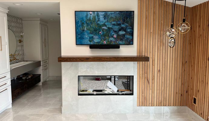 Custom TV installed above modern fireplace