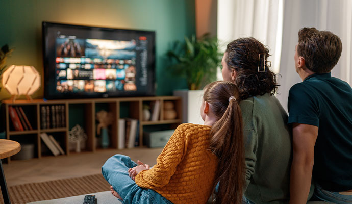 Family watching a streaming TV interface in a cozy living room