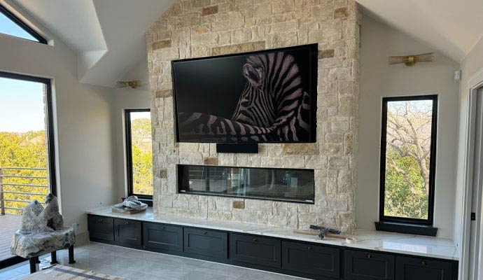 Flat-screen TV mounted above stone fireplace