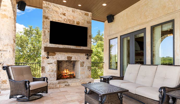 Outdoor patio with fireplace and mounted speakers