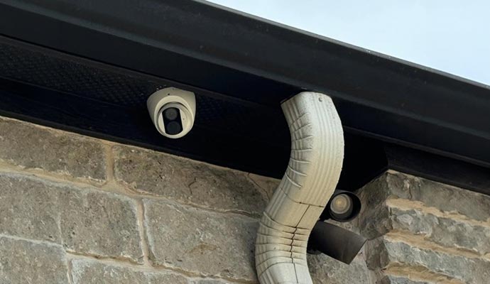 Outdoor security camera installed under soffit eave