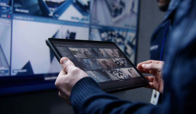 Person monitoring security video on a tablet