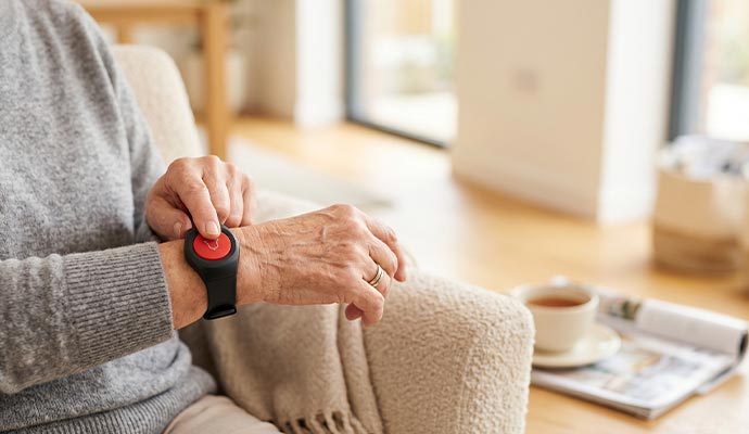 Senior using medical alert emergency button at home