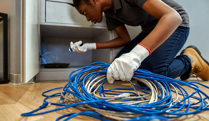 Technician inspecting network cables inside a cabinet