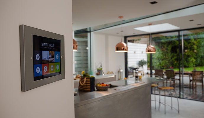 Wall-mounted smart home panel showing climate, lighting, security, and audio icons.