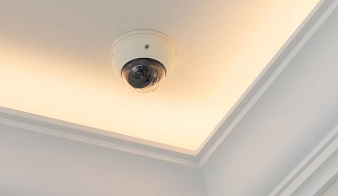 White dome security camera mounted on residential ceiling